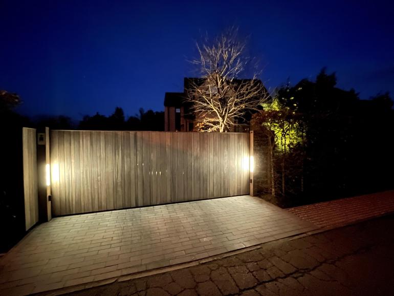 A wooden sliding gate with led lights on the sides