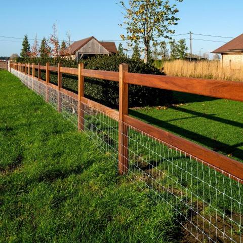 Wooden fence with square posts, 2 rails and a wire mesh on it