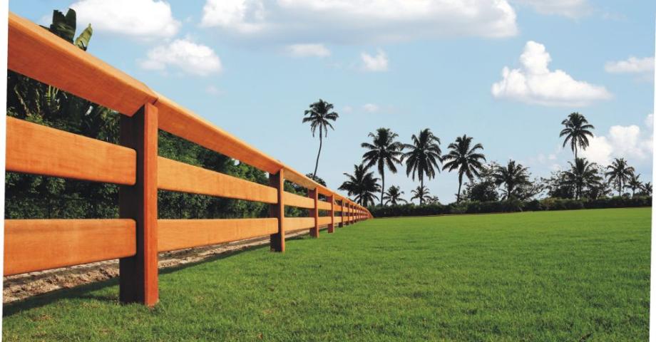 A wooden fence with two rails, boards that slide through the posts and a continuous top rail.